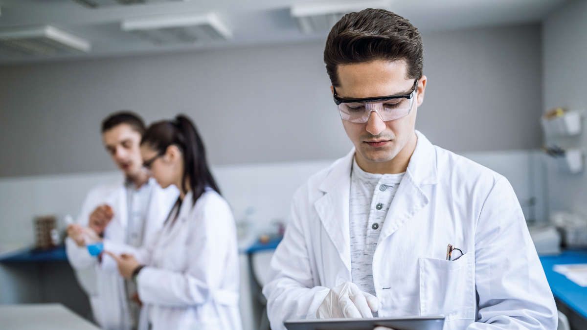  A young scientist notes research results on tablet