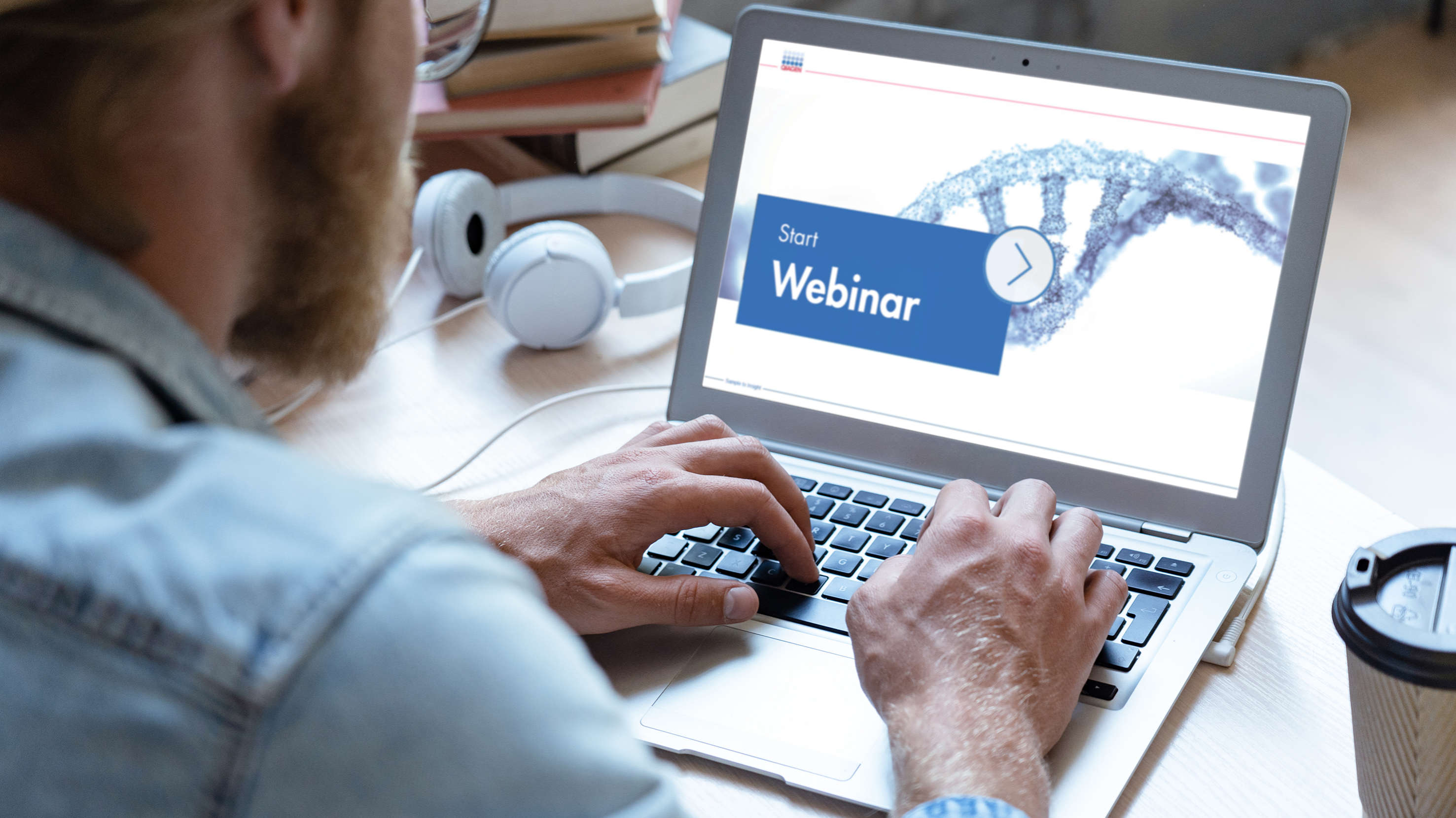 generic webinar image, male person sitting in an office watching a webinar, labtop, screen, work on comuter